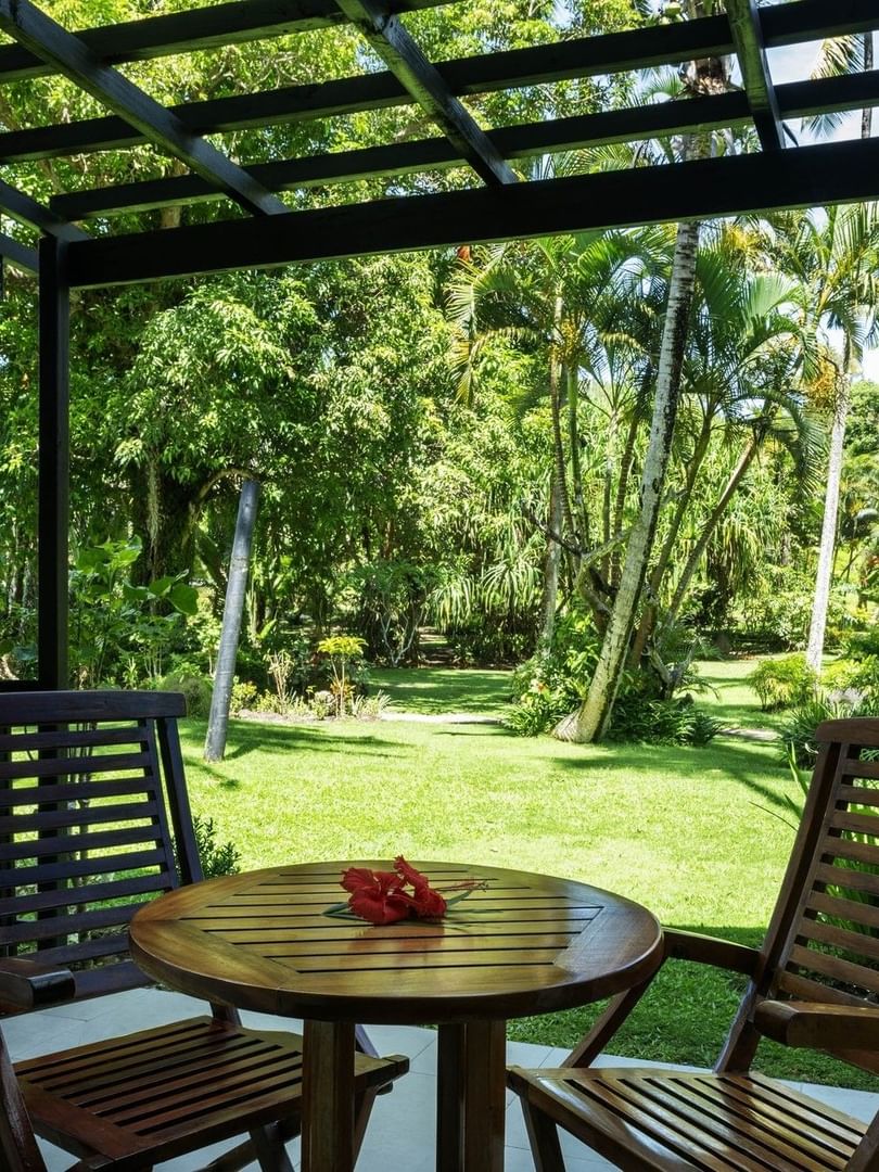 Two wooden chairs and table with garden view at Warwick Fiji Resort and Spa in Korolevu.