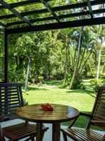 Two wooden chairs and table with garden view at Warwick Fiji Resort and Spa in Korolevu.
