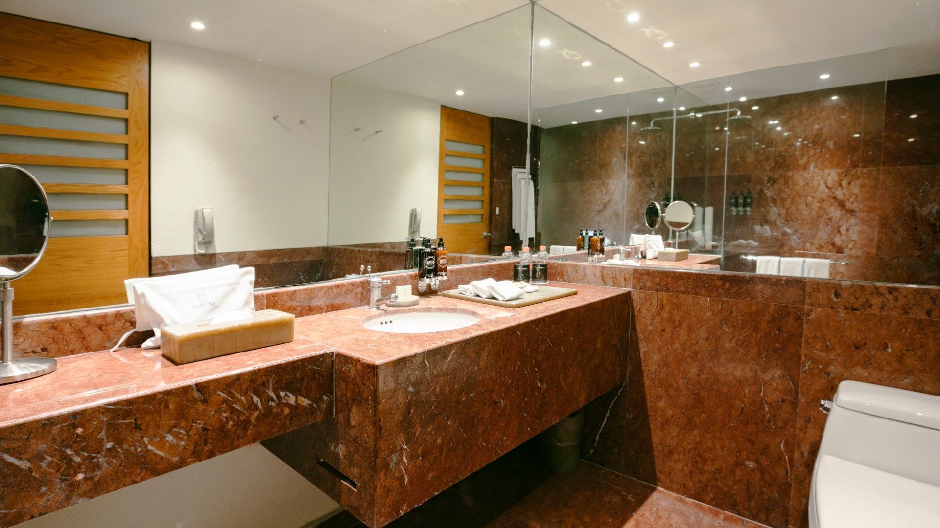 2 Double Deluxe upscale vanity with a large mirror and red marble countertops and walls at Camino Real Polanco Mexico