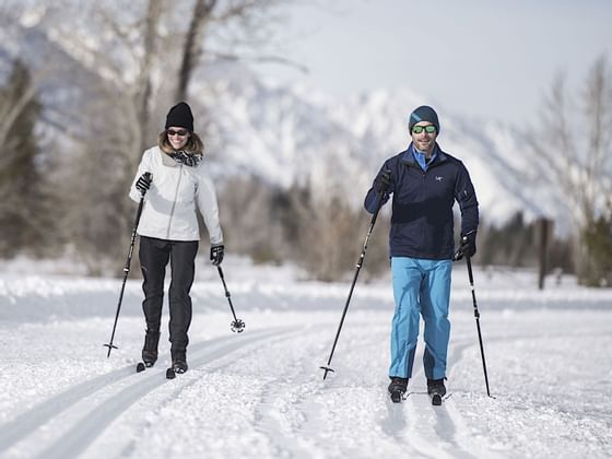 A couple Nordic skiing in snow near Hotel Jackson