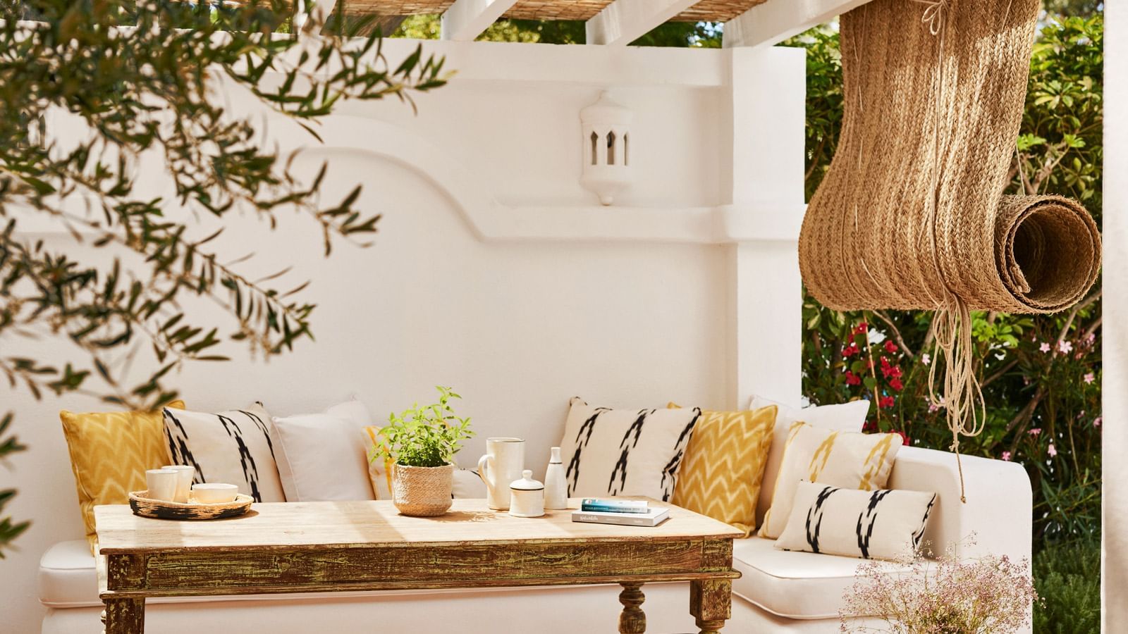 Casabel, featuring a built-in sofa and a wood table placed under a pergola at Marbella Club