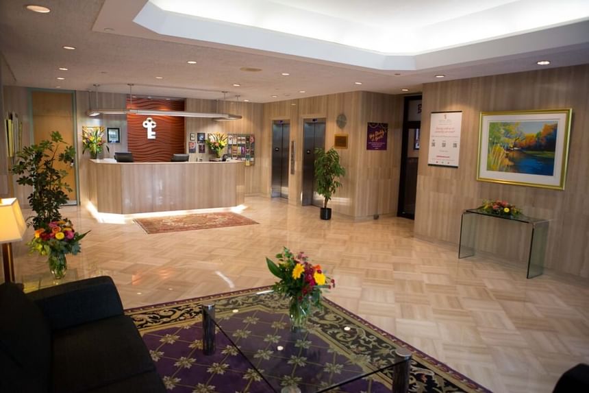 Lobby with front desk & flowers at Cartier Place Suite Hotel