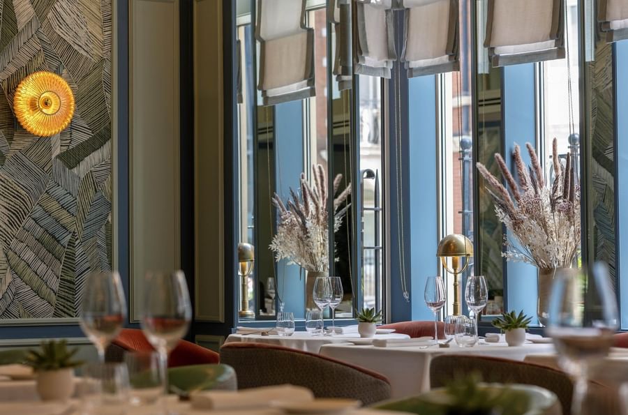 Dining tables set, by mirrors, under dried bouquets in the restaurant at The Capital Hotel, Apartments and Townhouse