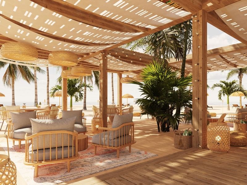 Salón relajante frente a la playa en Fiesta Americana Funeeq Punta Cana con sillones y lámparas de mimbre bajo sombra
