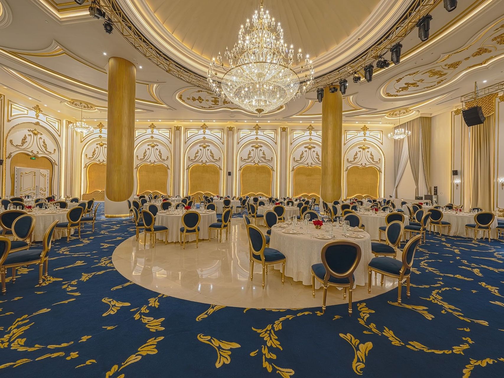 Elegant banquet hall with blue carpet and gold accents at World Heart Hotel Baghdad.