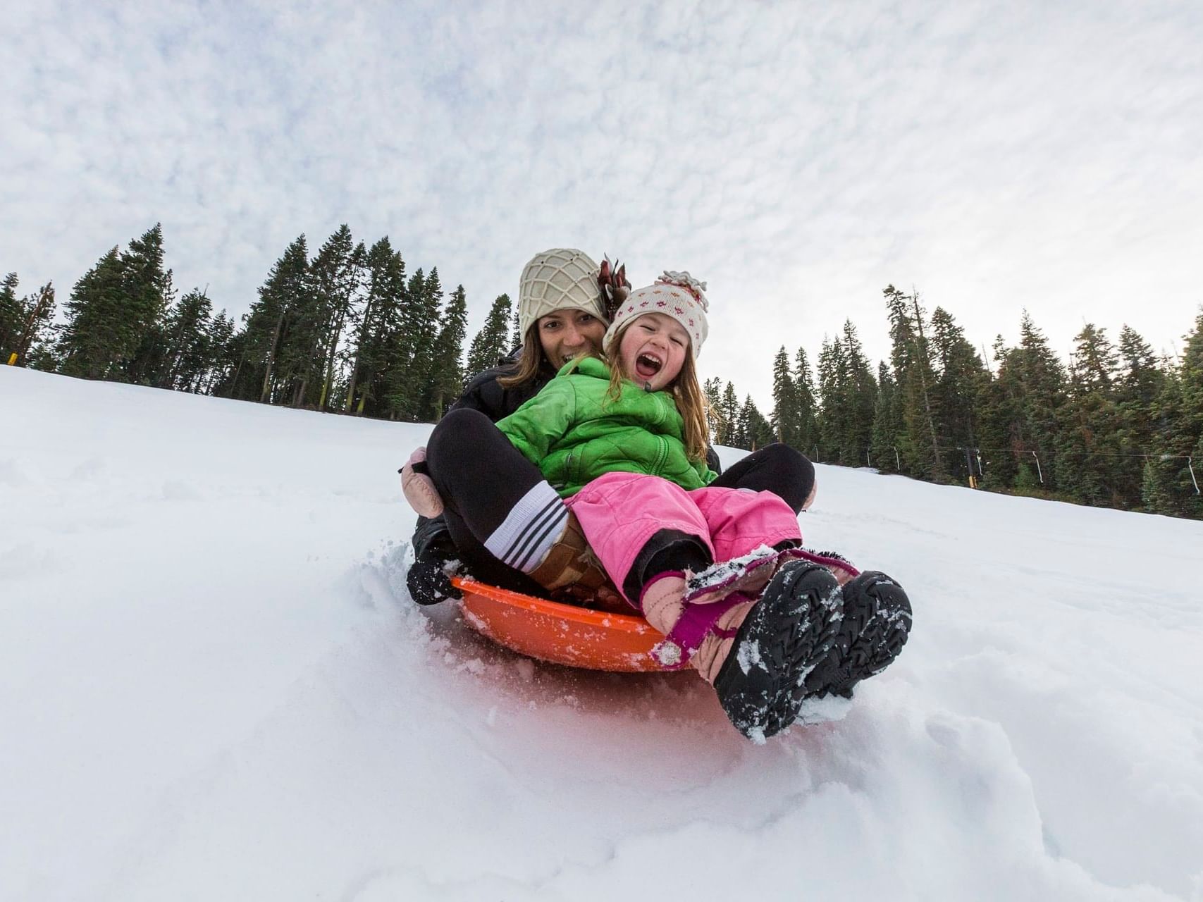 Mom & kid sledding on snow at Granlibakken Tahoe