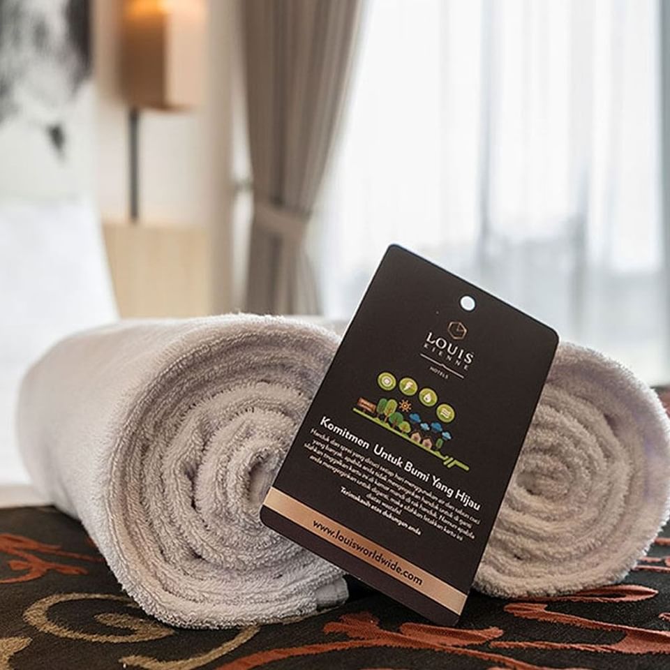 Close-up of rolled towels on the bed in King Bed Deluxe Room at LK Cikarang Hotel & Residences