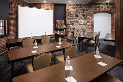Classroom type table set-up with projector screen in Savannah Meeting Spaces at River Street Inn