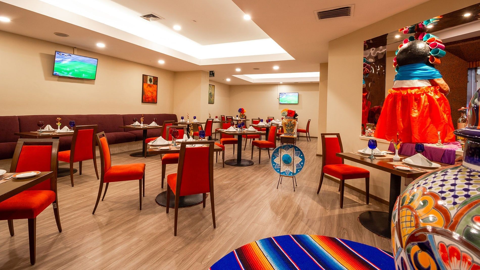 Elegant dining area with set tables and vibrant decor at Cualli, Camino Real Aeropuerto Mexico in Ciudad de Mexico.