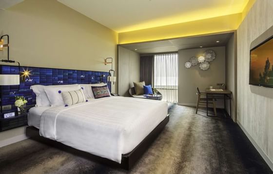 Double bed with a work desk in Deluxe Room at U Hotels & Resort