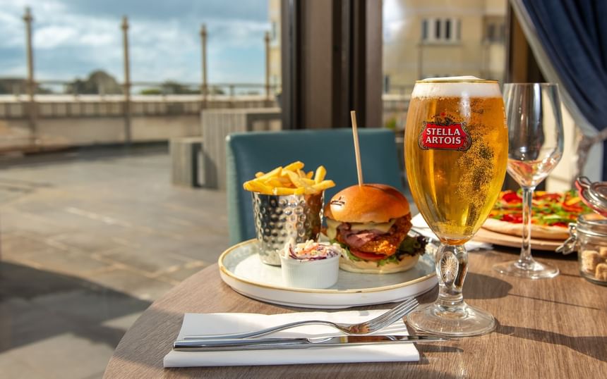 Stella Artois glass and a meal on a table with sea view at The View Hotel Eastbourne
