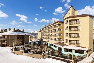 Aerial view of Elevation Resort & Spa's modern lodge with snowy surroundings and outdoor dining area