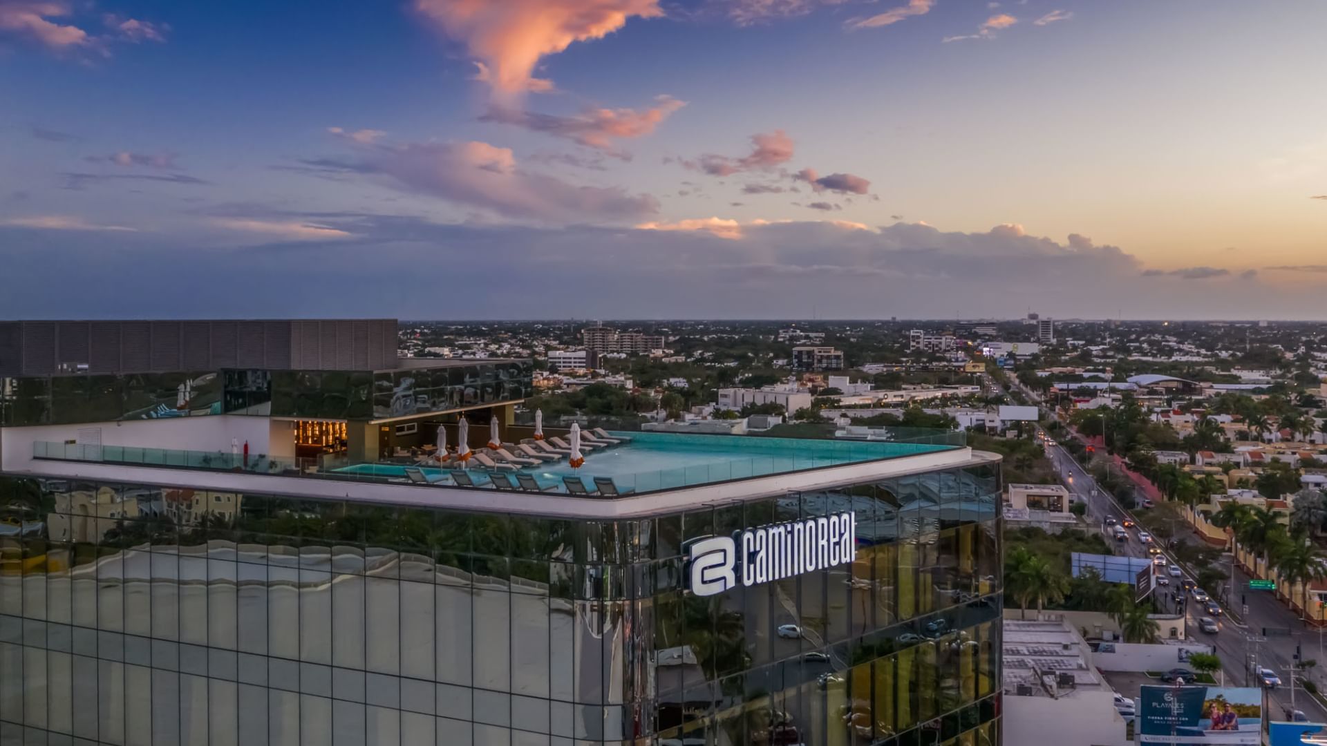 Real Inn Perinorte, formerly Camino Real Mérida hotel Mexico, featuring vibrant orange architecture and palm trees