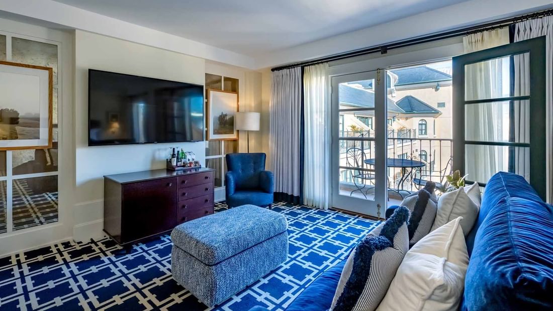 TV lounge area with plush seating and carpeted flooring in Courtyard Grand Executive King Suite at El Prado Hotel