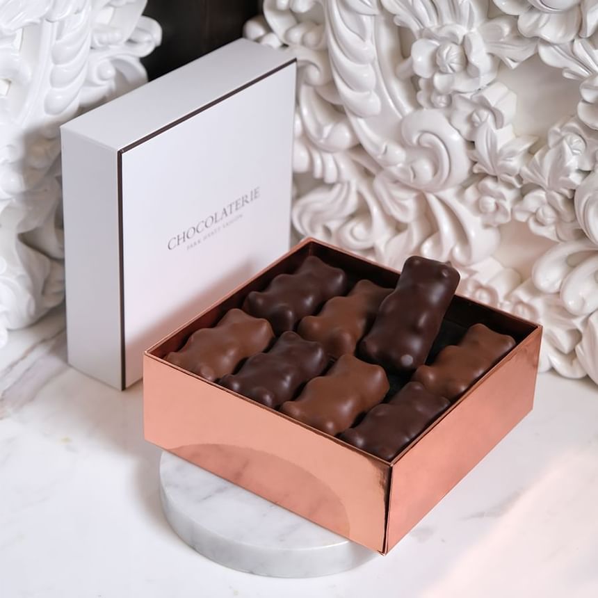 Box of chocolate treats featuring various shapes, displayed on a marble surface, served in Chocolaterie at Park Hyatt Saigon