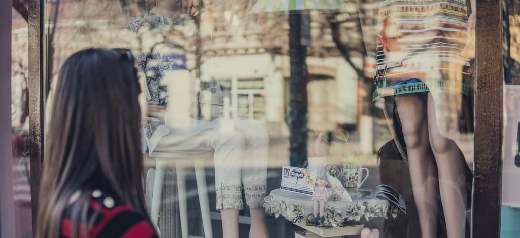 A person looks in a store window while on a Canmore shopping trip.