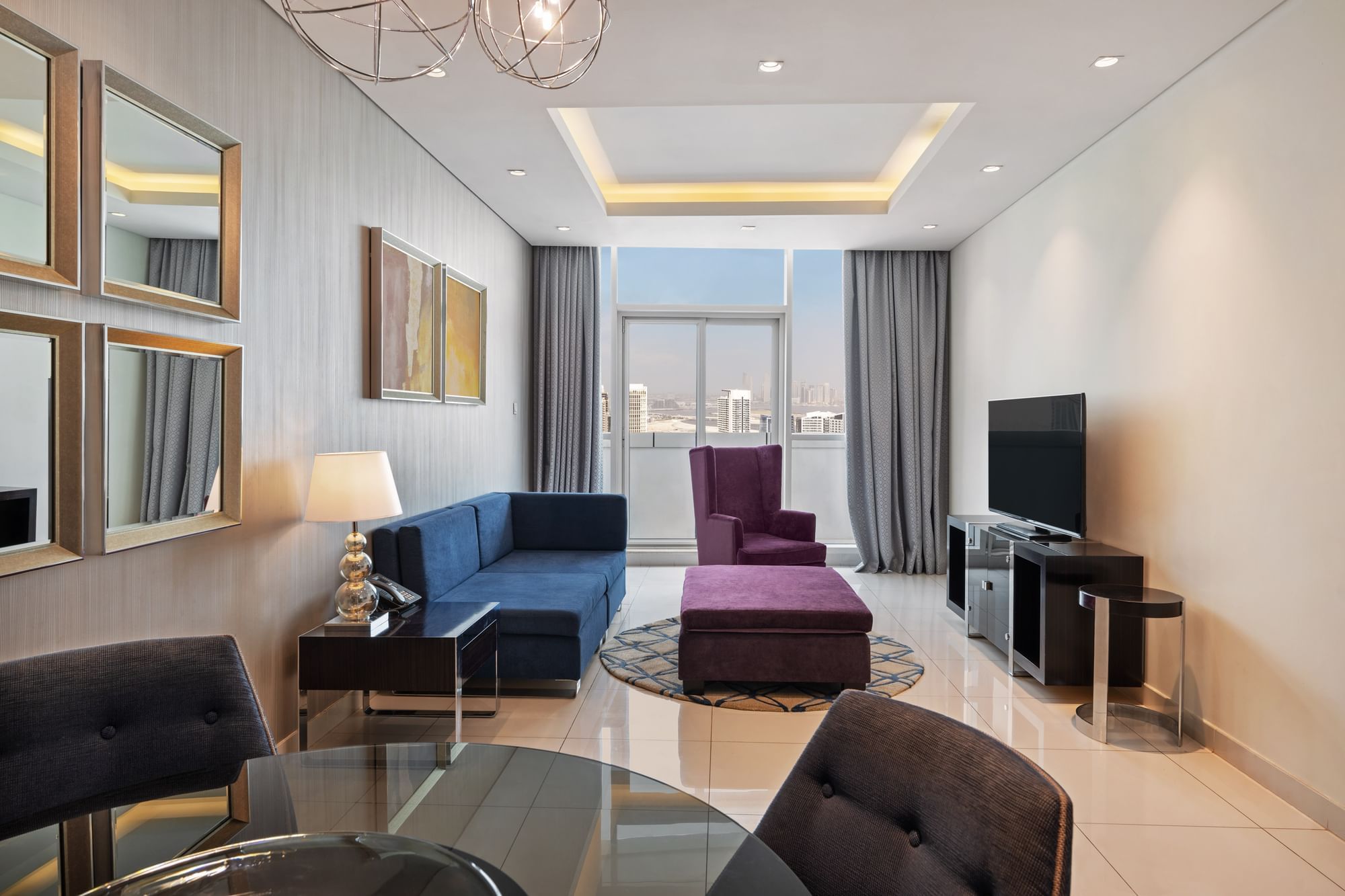 Dining table by TV lounge area in Two Bedroom Suite at DAMAC Maison Distinction, a suite hotel in Dubai