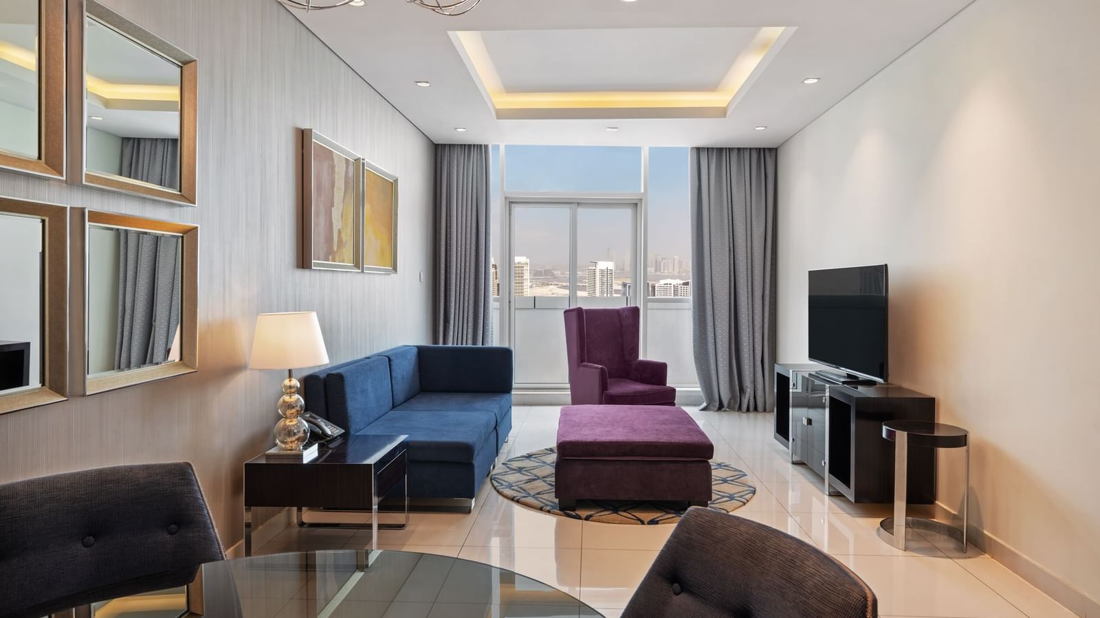 Dining table by TV lounge area in Two Bedroom Suite at DAMAC Maison Distinction, a suite hotel in Dubai