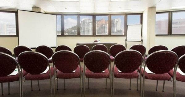 Meeting room with chairs facing a projector screen