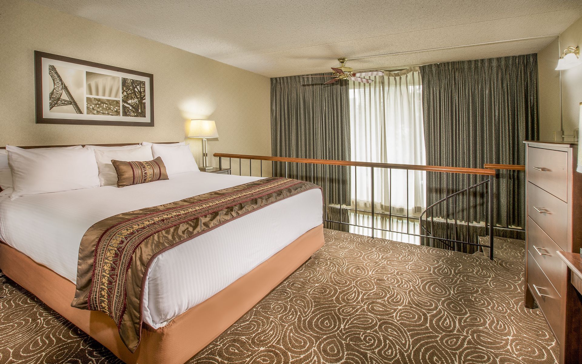 Bed in modern hotel suite with stairs