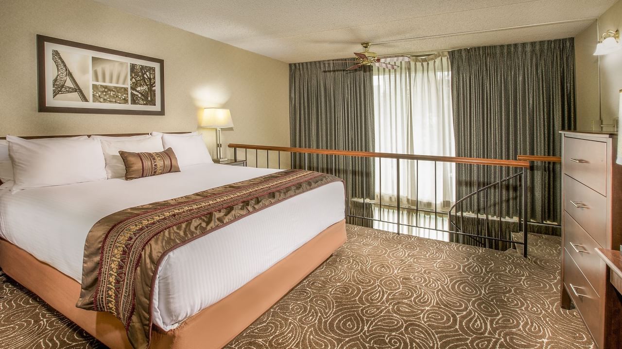 Bed in modern hotel suite with stairs