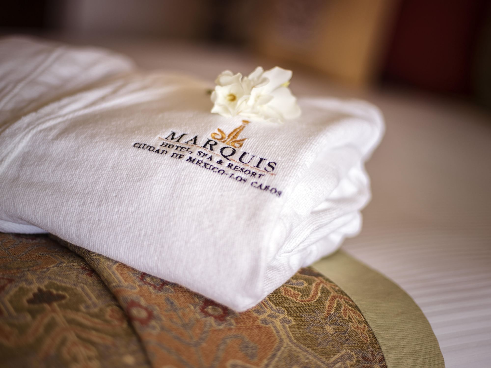 Closeup of a folded bathrobe on a bed in Marquis Los Cabos