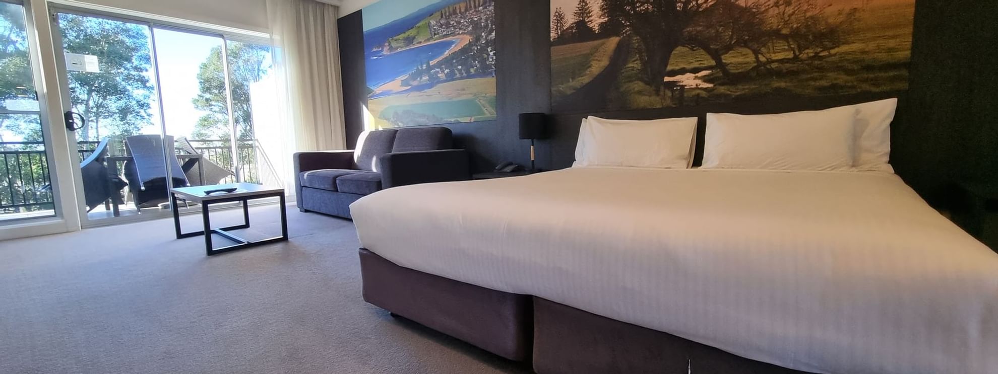 Bed and sofa in Deluxe Room at  Mercure Gerringong