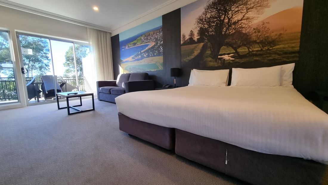 Bed and sofa in Deluxe Room at  Mercure Gerringong