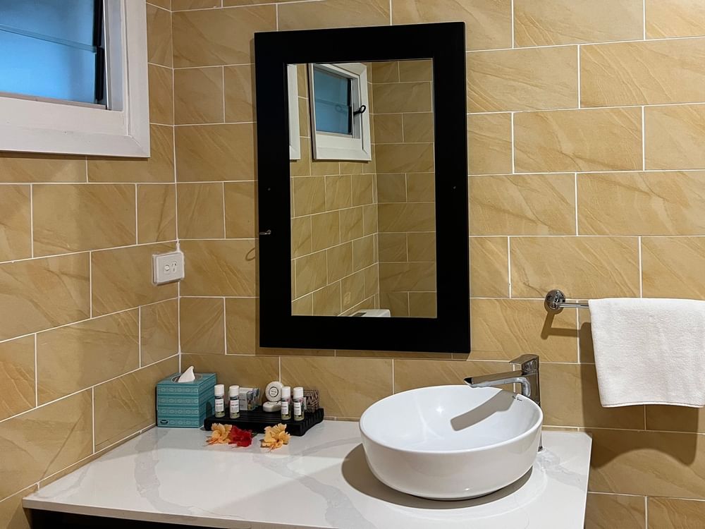 Bathroom sink with mirror and towel in the Ocean View Villa at Tambua Sands Beach Resort in Sigatoka.