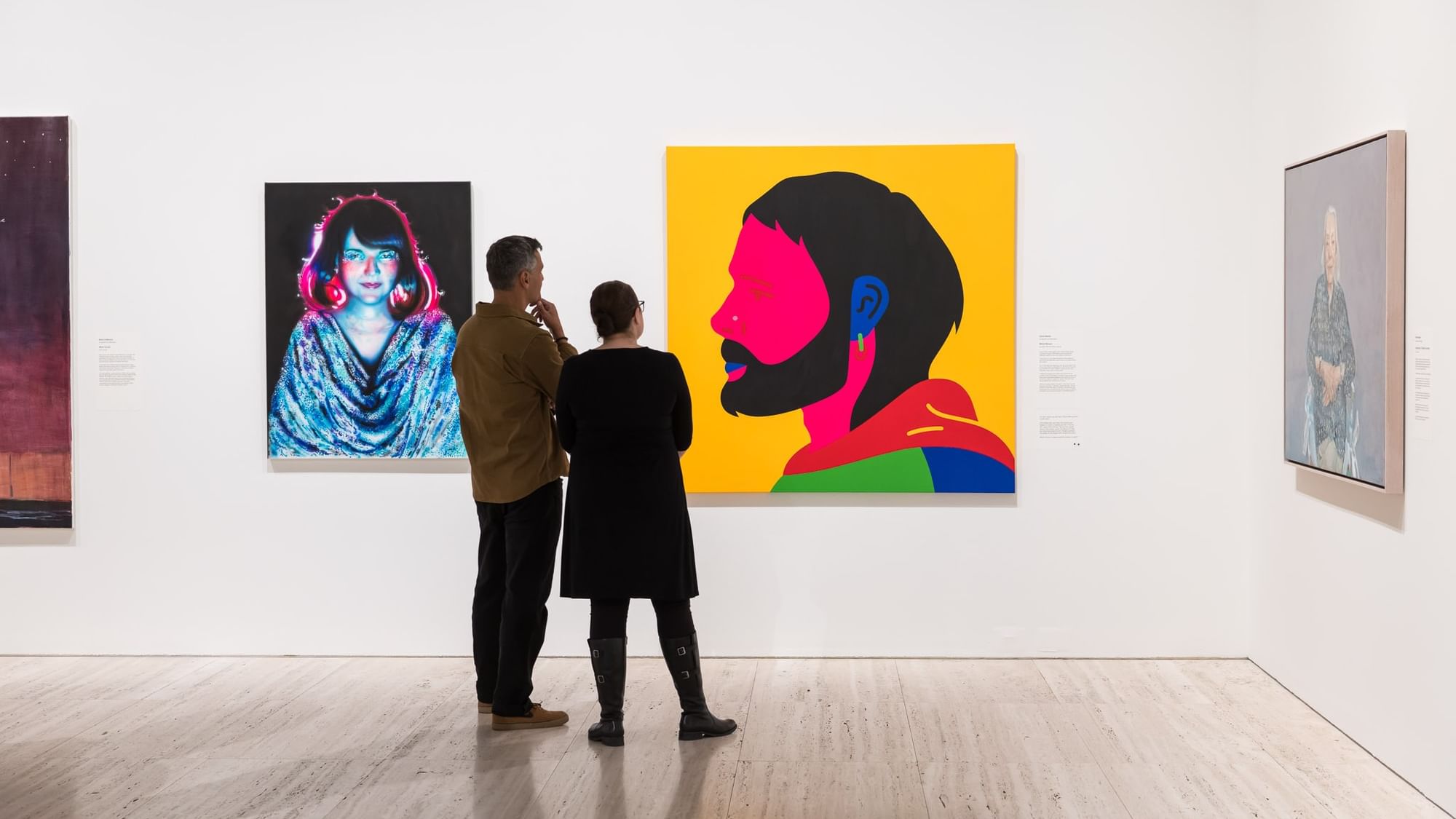 Two people admiring art paintings in Archibald 2026.