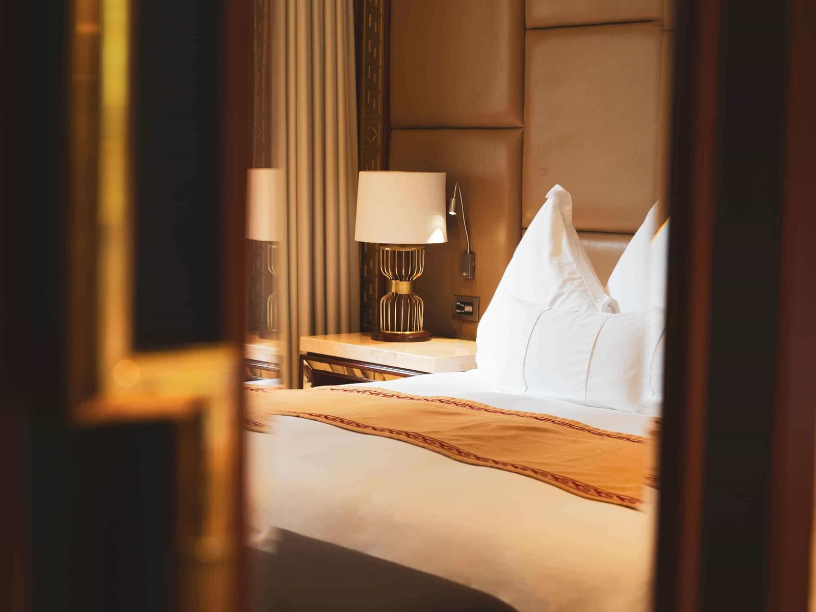 Imperial Suite with River View featuring plush bedding, elegant lamps, and warm tones at Sumaq Machu Picchu Hotel