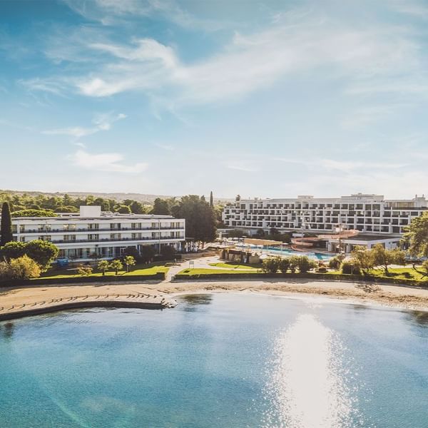 Aerial view of a beachfront resort with swimming pool on a sunny day at Falkensteiner Hotels & Residences