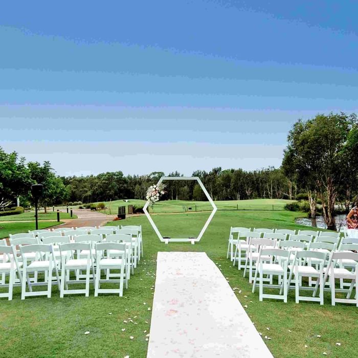 Stunning wedding ceremony set up with white arch and chairs at Mercure Kooindah Waters