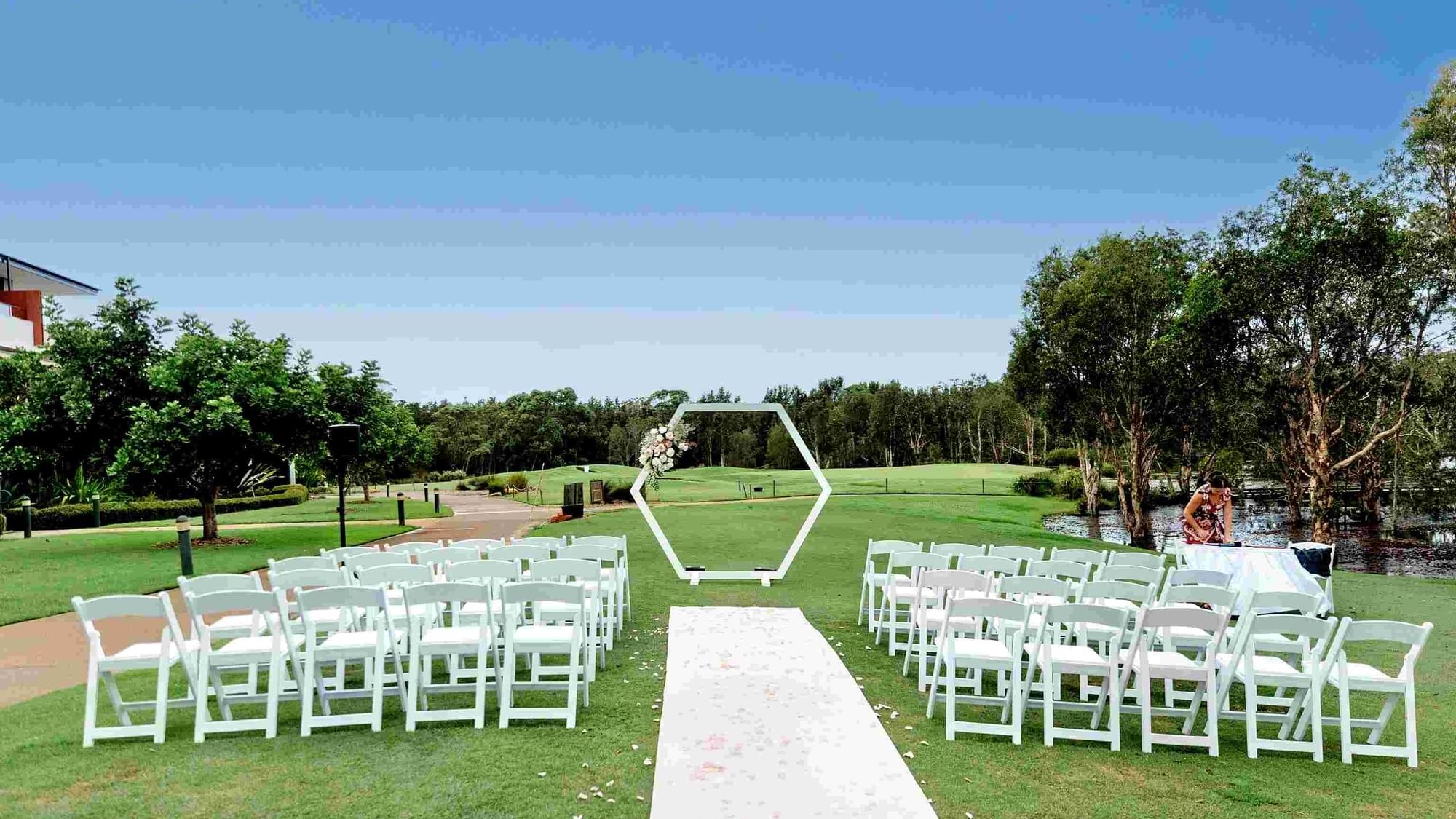 Stunning wedding ceremony set up with white arch and chairs at Mercure Kooindah Waters