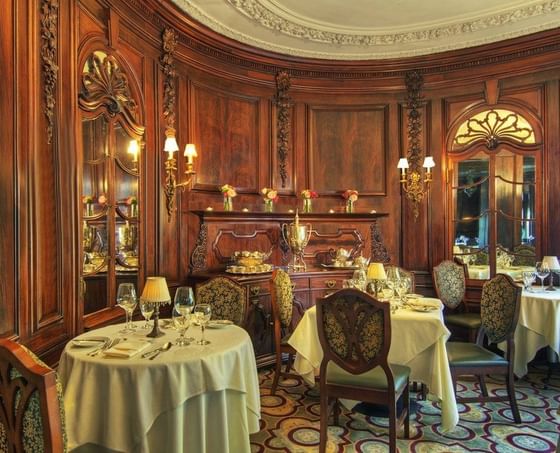 An elegantly set dining room with ornate wood paneling and classical decor at The Pointe at Castle Hill