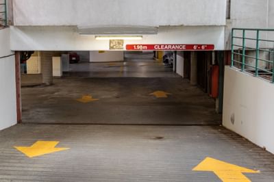 Parking garage entrance with low-clearance sign and yellow arrows at Rosedale on Robson Suite Hotel
