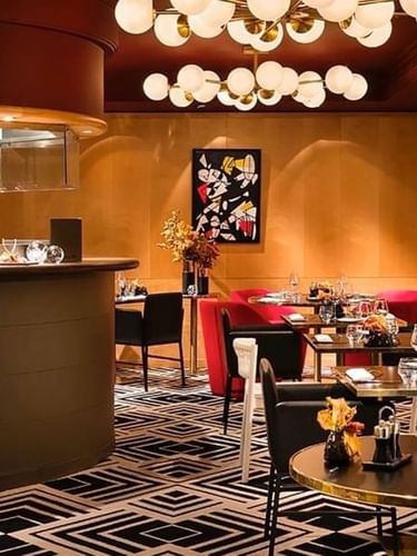 L'intérieur raffiné du restaurant « Le W », avec ses tables et son bar, au Warwick Champs-Élysées à Paris.