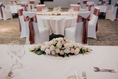 Elegant wedding reception setup with tables, pink and white floral centerpieces at The Aberdeen Dyce Hotel