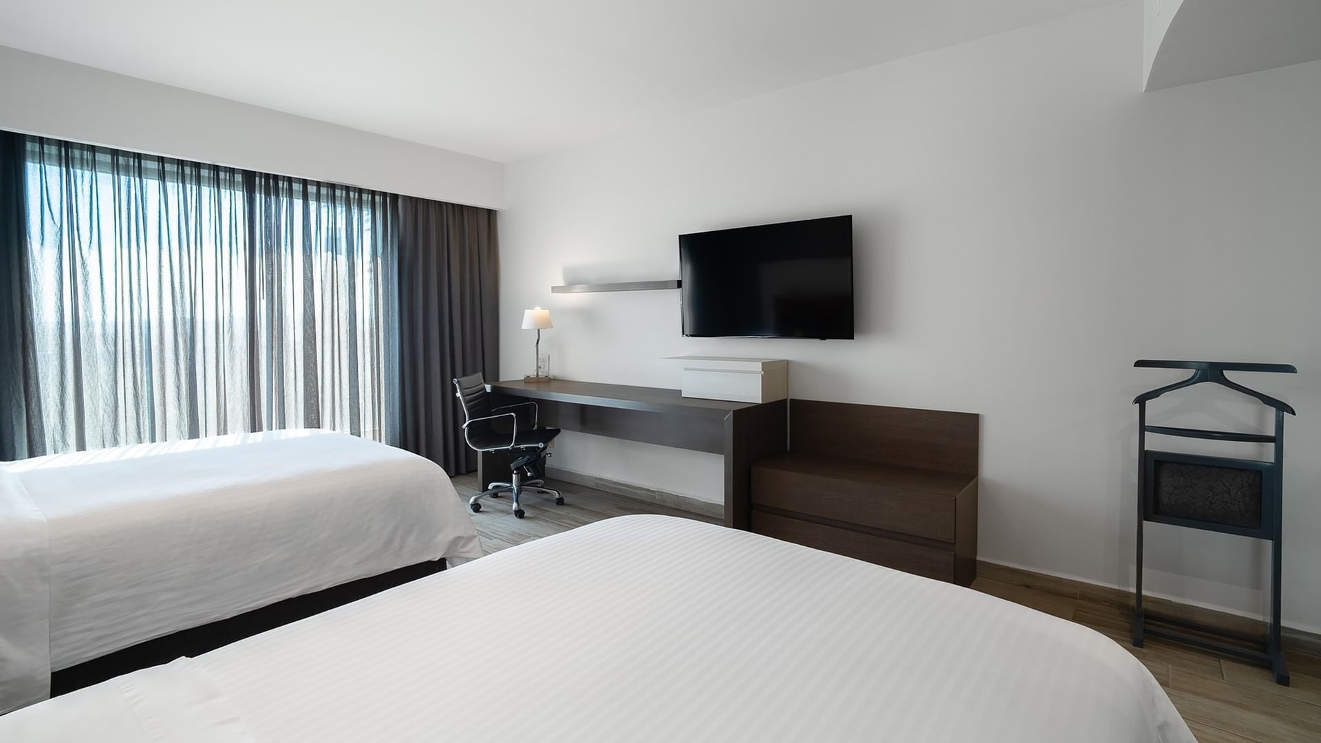 Habitación lujosa con dos camas dobles, escritorio y televisión en Real Inn Perinorte Tlalnepantla.