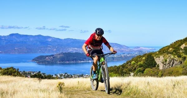 Mountain biker riding along a coastal trail in Wellington, New Zealand