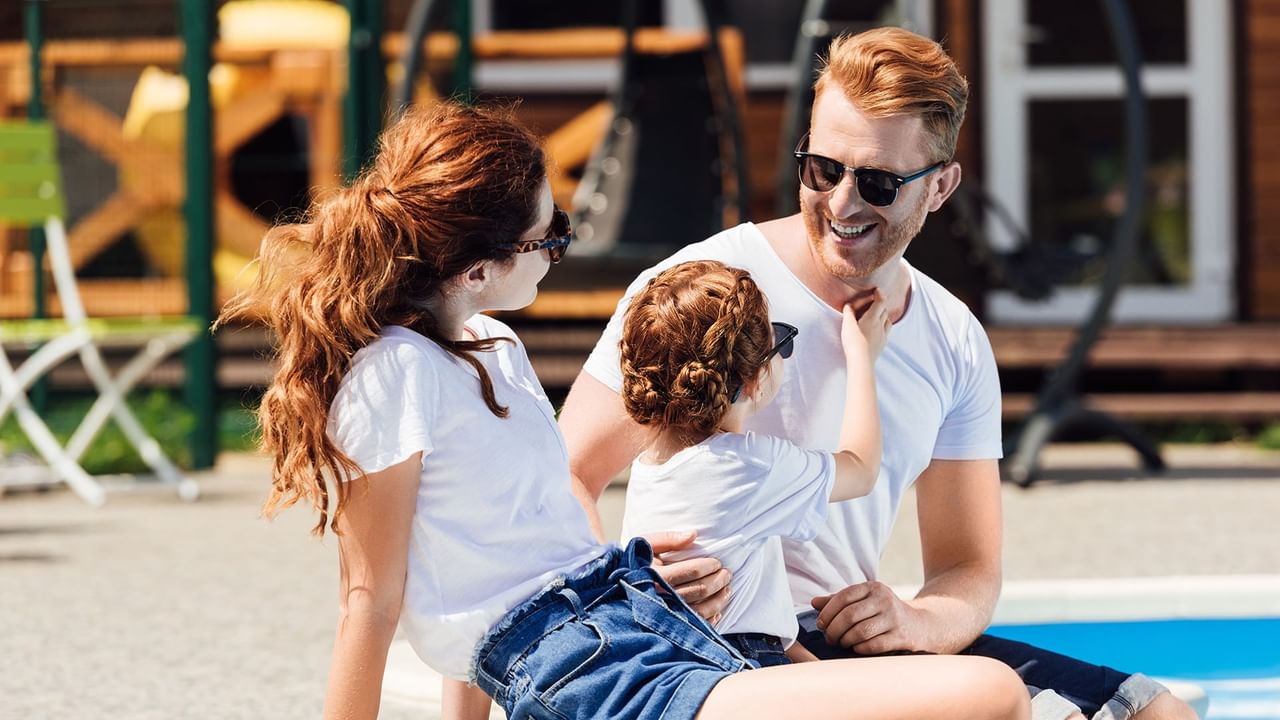 family sitting by a pool