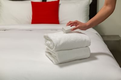 Woman placing a box on top of towels on a bed at ReStays Ottawa