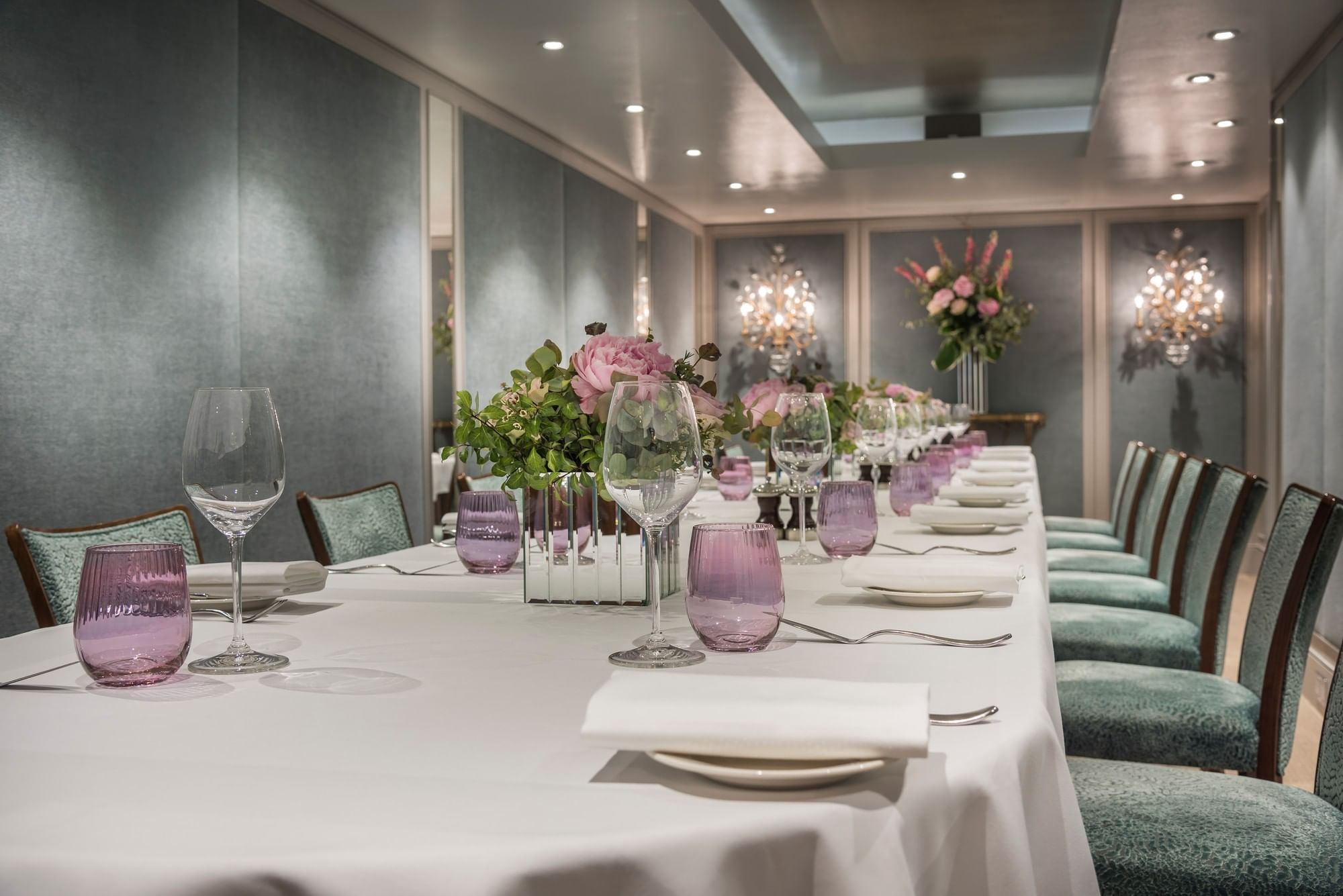 Long dining table set with glasses & floral arrangements in Cadogan Suite at The Capital Hotel, Apartments and Townhouse
