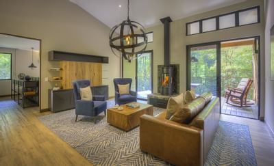 salón con sofá, mesa de centro, chimenea y puerta a balco