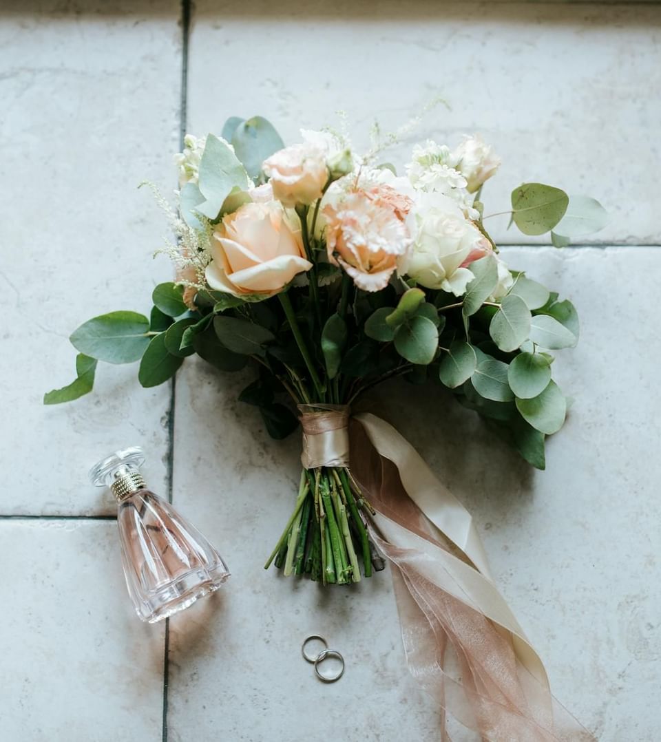 Bouquet of soft pink and white flowers on a tiled surface beside a perfume bottle at Ananea Madivaru Maldives
