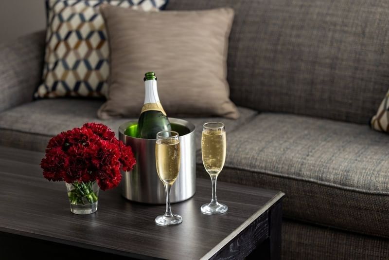 Bottle of champagne in an ice bucket with two filled glasses and red flowers on a table at Shangri-La Resort and Golf Club