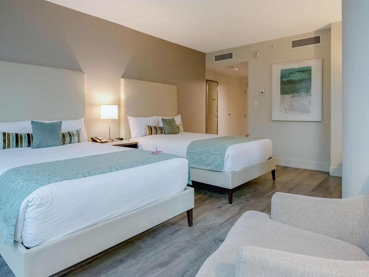 room with two double beds and sofa chair