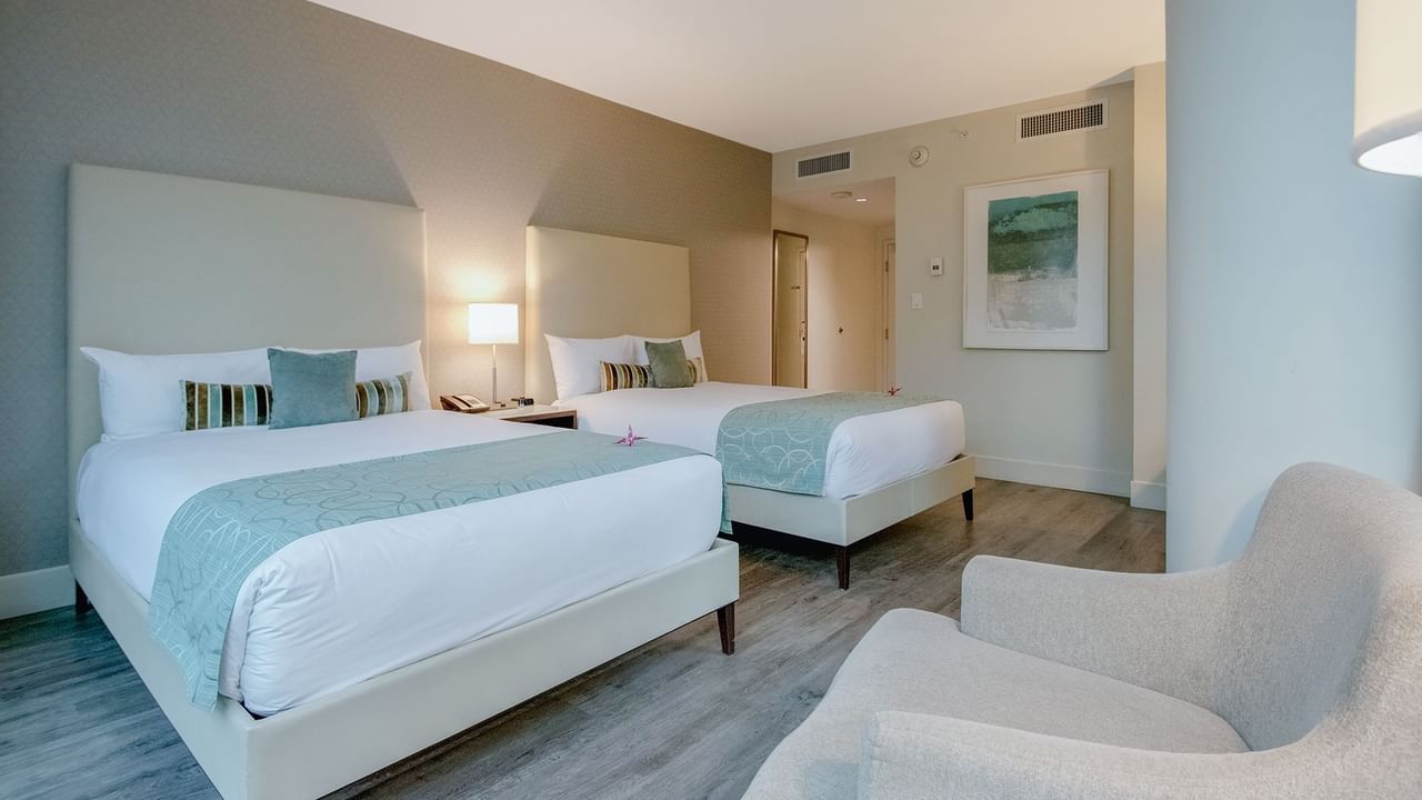 room with two double beds and sofa chair