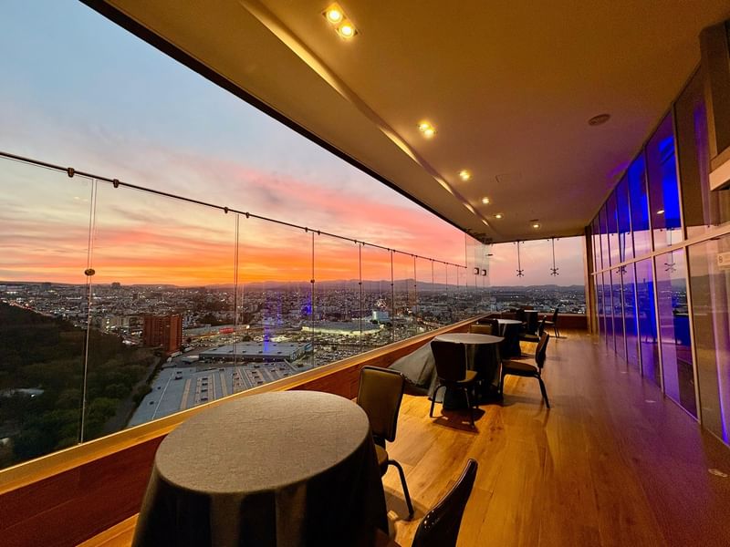 Elevated dining area with glass railings, offering cityscape views at Tangamanga Terrace, Fiesta Americana San Luis Potosí