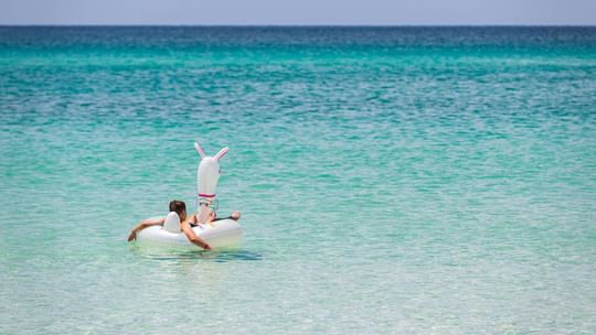Man relaxing on an inflatable float in the sea at Watersound Inn